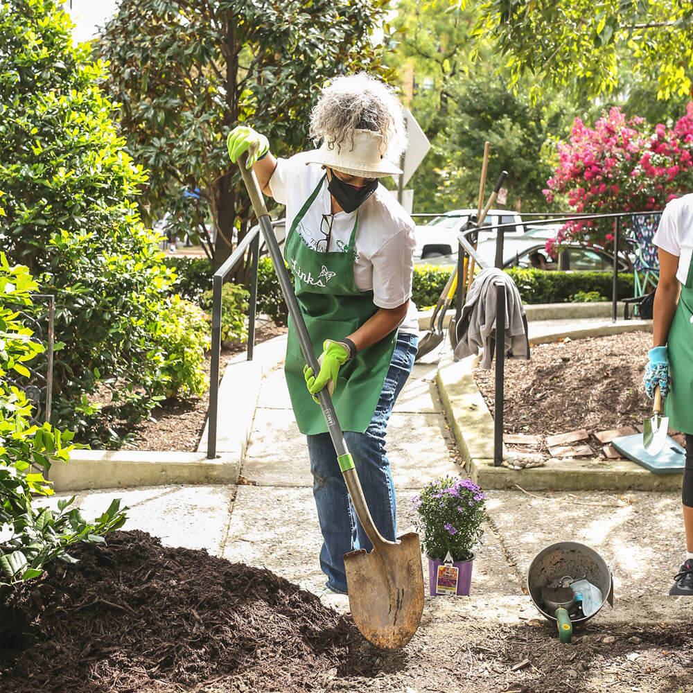 Member from The Link gardening/digging a hole