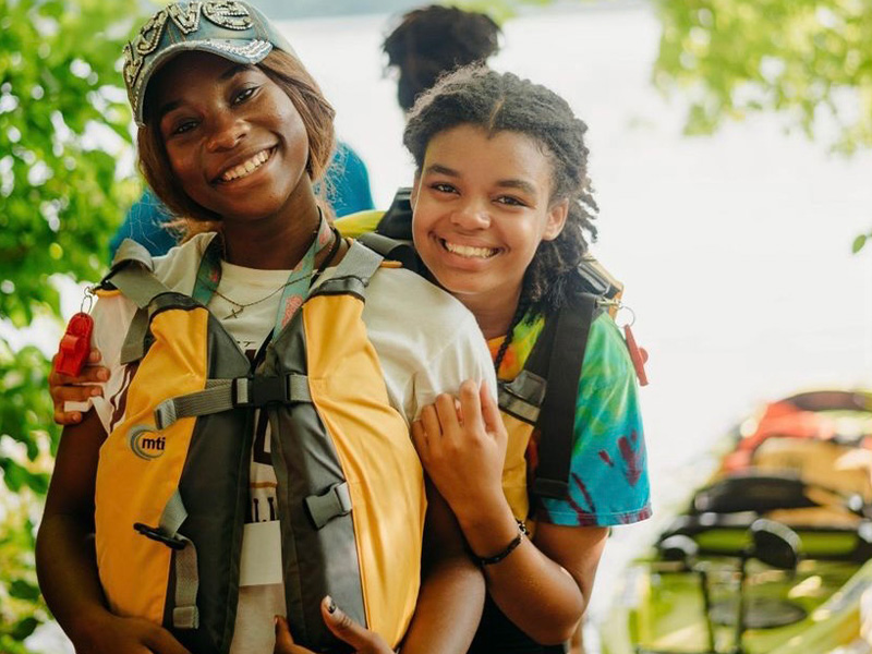 Two girls getting prepared to go kayaking