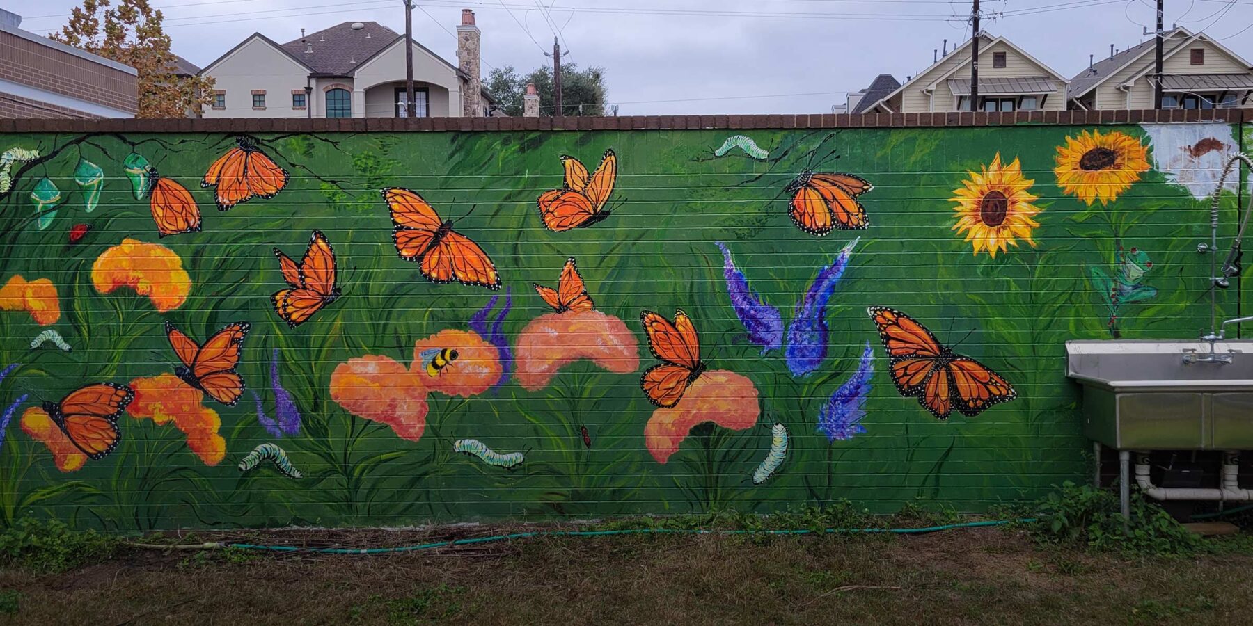 Baker Mural showing orange butterflies and flowers on a green background.