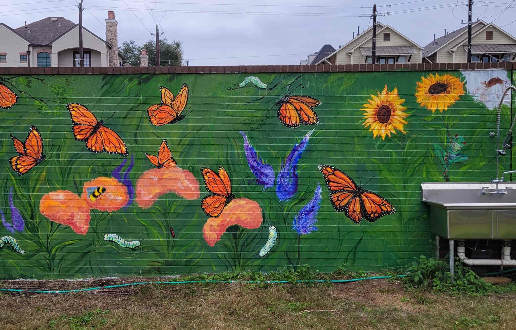 Baker Mural showing orange butterflies and flowers on a green background.