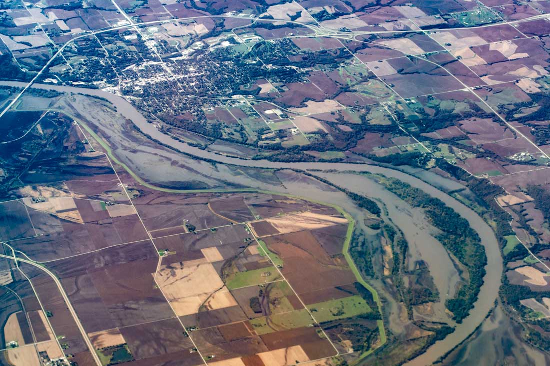 Aerial view of flood plain along the Missouri River at Nebraska City, Nebraska, USA. View looking south. Green levee (Army Corps of Engineers, Missouri River Levee System L-575) dividing farmland in Iowa from flood plain visible to left of river.