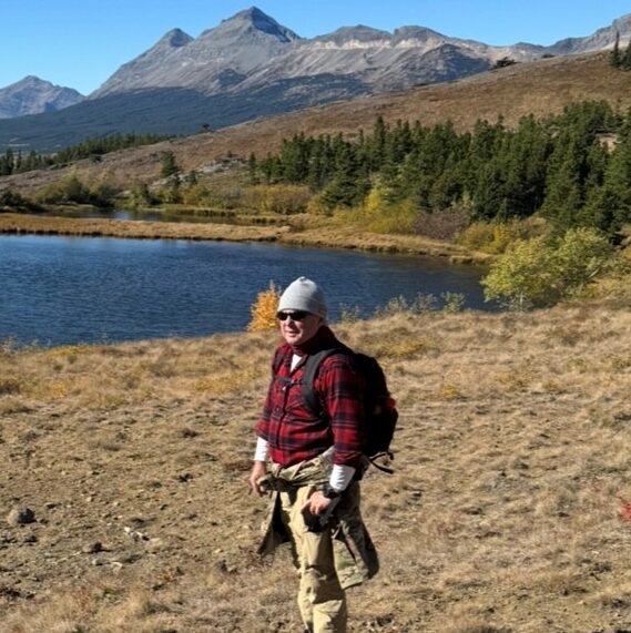 Photo of Harlan from California, standing beside a lake